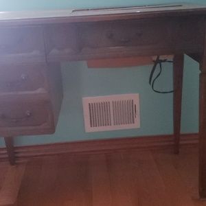 Desktop that has a sewing machine attached to it